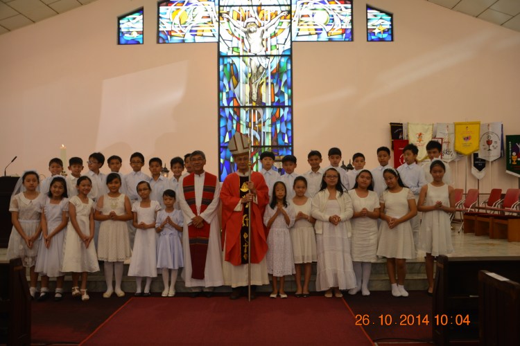 The first Holy Communicants in a group photo with Archbishop John Wong and Rev Fr Cosmas Lee.